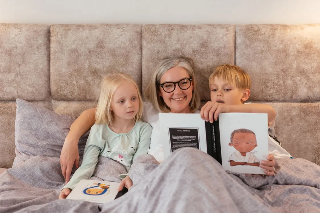 Grandparent burnout — an exhausted grandparent resting in an armchair surrounded by toys