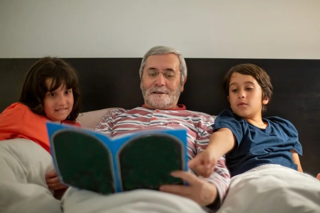 Grandparent and grandchild reading a bedtime story at their house